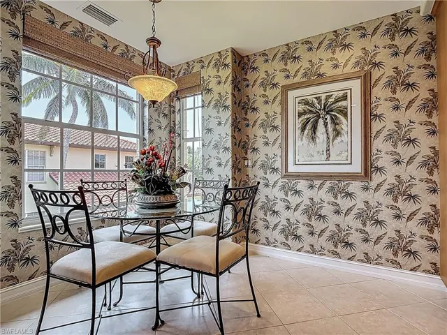 Dining space with wallpapered walls, baseboards, and light tile patterned flooring