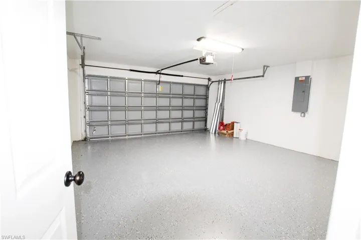 Garage with electric panel and a garage door opener