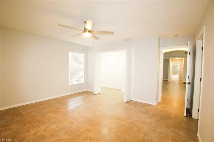 Unfurnished room with baseboards and ceiling fan
