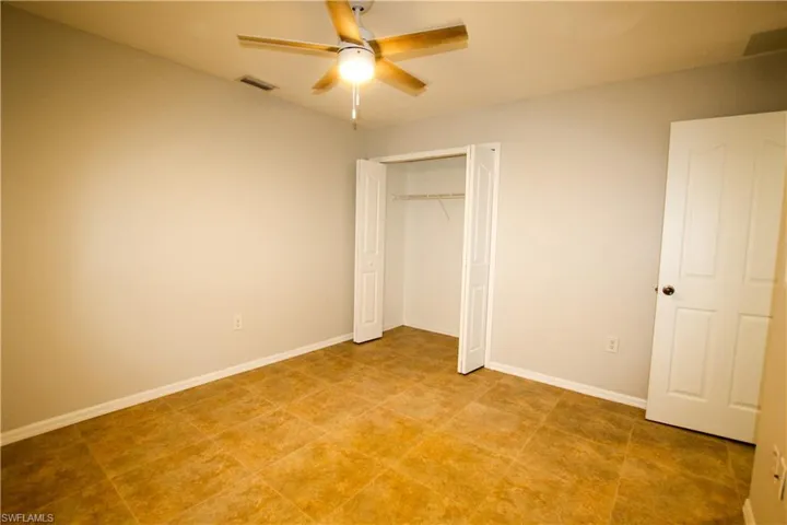 Unfurnished bedroom with a ceiling fan and a closet