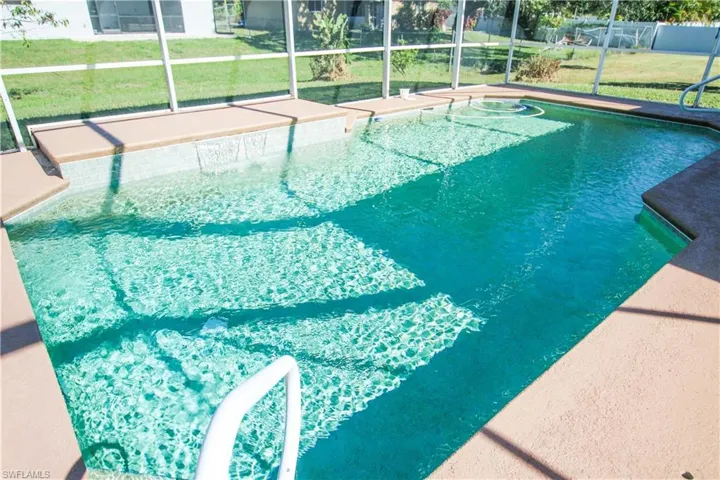 View of swimming pool with a lawn, a lanai, and a sunroom