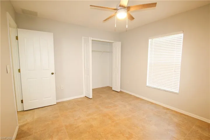 Unfurnished bedroom with a ceiling fan and a closet