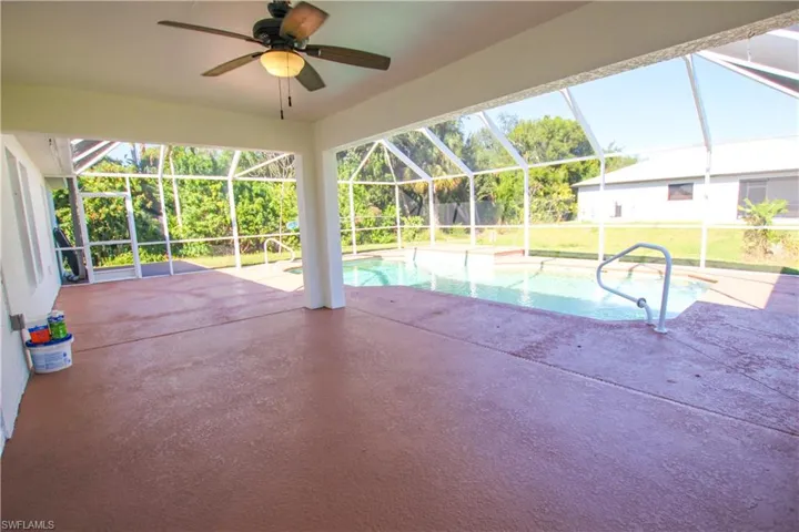 Outdoor pool with a patio, a sunroom, a ceiling fan, a lanai, and a lawn