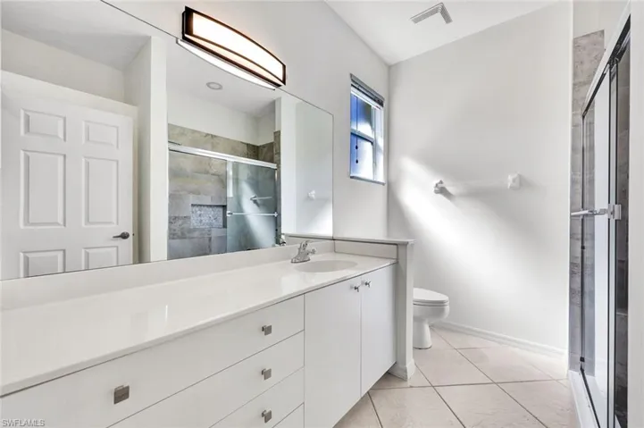 Master Bathroom featuring vanity, a tile shower, and light tile patterned flooring