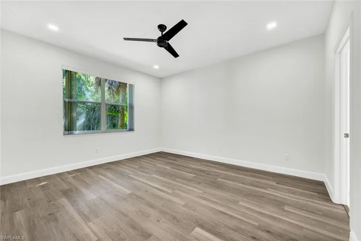 Master bedroom with a ceiling fan, light laminaate wood-style flooring, and recessed lighting