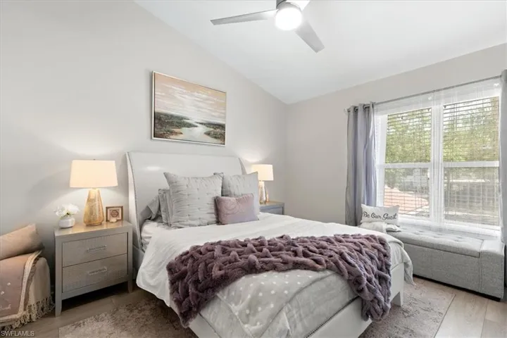 Bedroom with vaulted ceiling, LVT floors, and ceiling fan