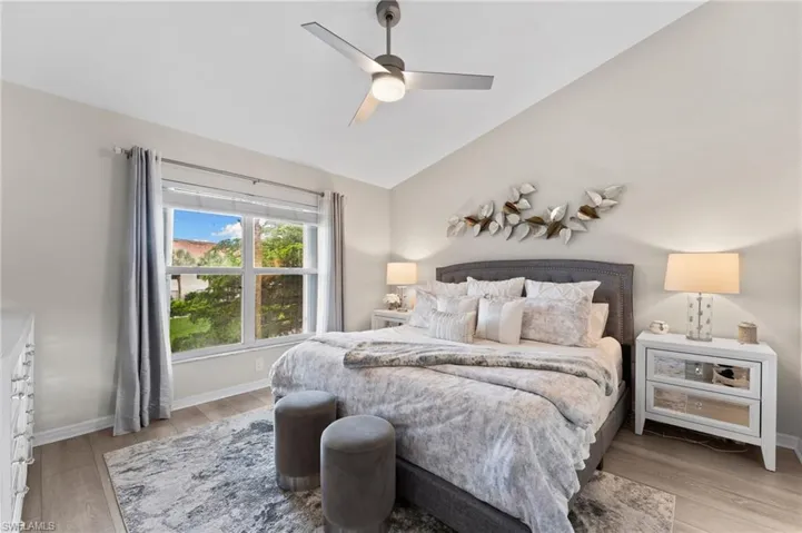 Bedroom with vaulted ceiling, wood finished floors, and a ceiling fan