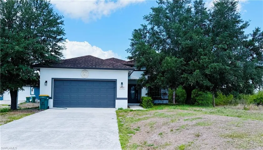 Contemporary single-story residence featuring a two-car garage with a paneled door, a paved driveway, and a shingle roof
