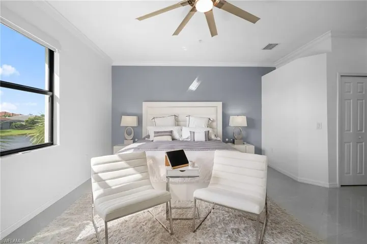 Room featuring a window with exterior views, crown molding, a ceiling fan, and a paneled interior door