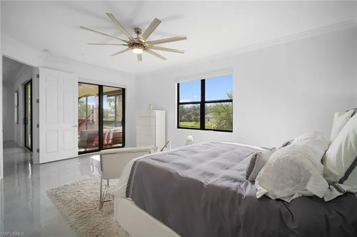 Bright interior with glossy tile flooring, a large multi-blade ceiling fan, and crown molding