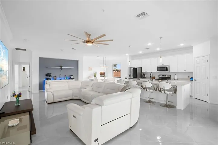 Open-concept living area with polished tile flooring, a contemporary ceiling fan, and recessed lighting