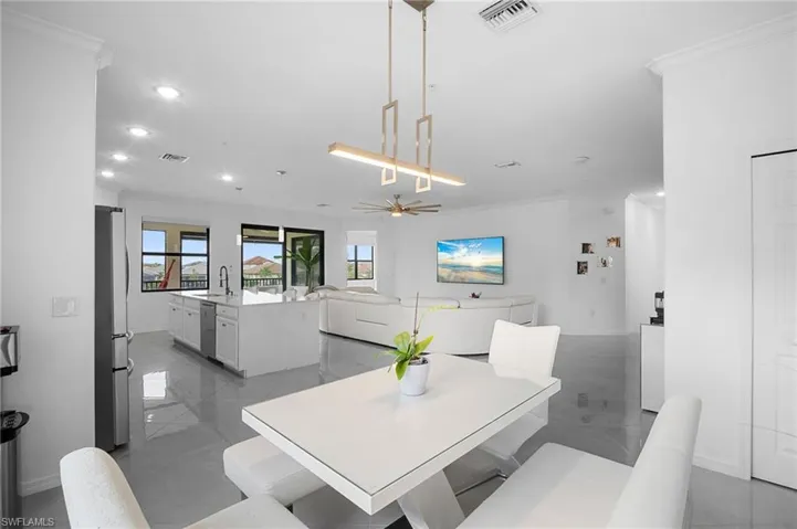 Open-concept living area with tile flooring and a modern linear chandelier