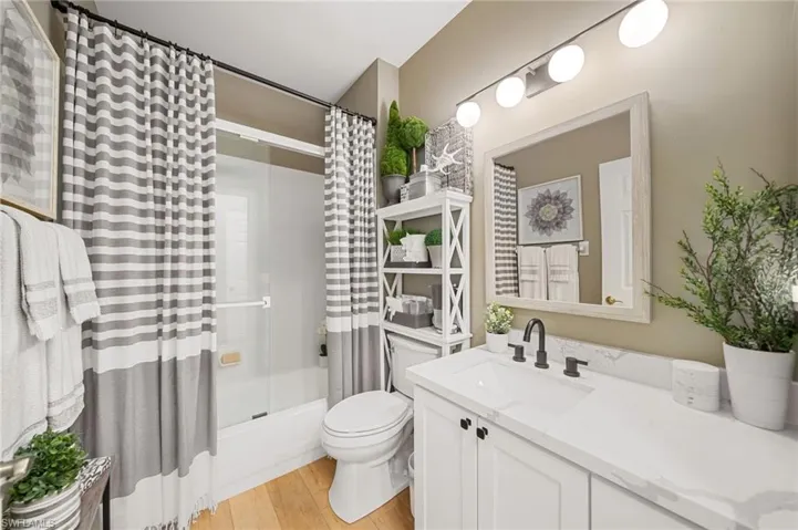 hall bath with new fixtures, quartz tops, tile bath and shower combo