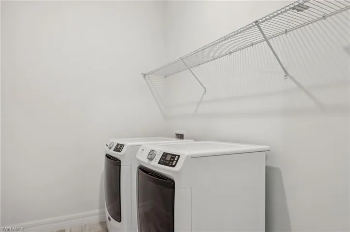 Washroom with baseboards, washer and dryer, and laundry area