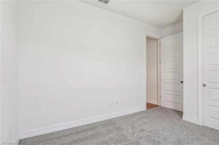 Unfurnished bedroom with carpet flooring and baseboards