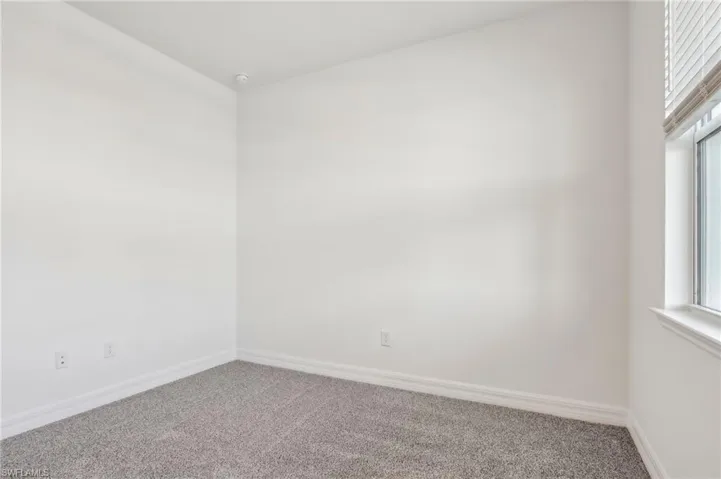 Empty room with carpet flooring and baseboards