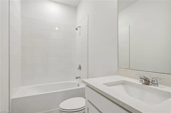 Full bath featuring shower / bath combination, vanity, and toilet