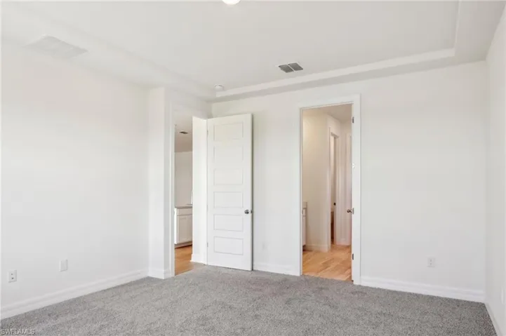 Unfurnished bedroom with visible vents, baseboards, and carpet