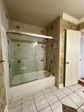 Bathroom with a built-in tub and sliding glass shower doors