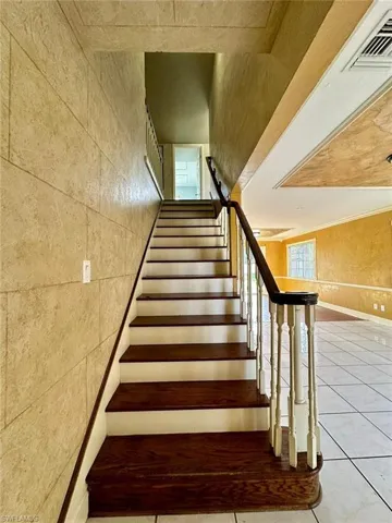 Staircase featuring dark wood-finish treads and white risers