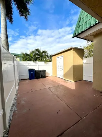 Paved concrete patio with perimeter fencing and an exterior storage shed