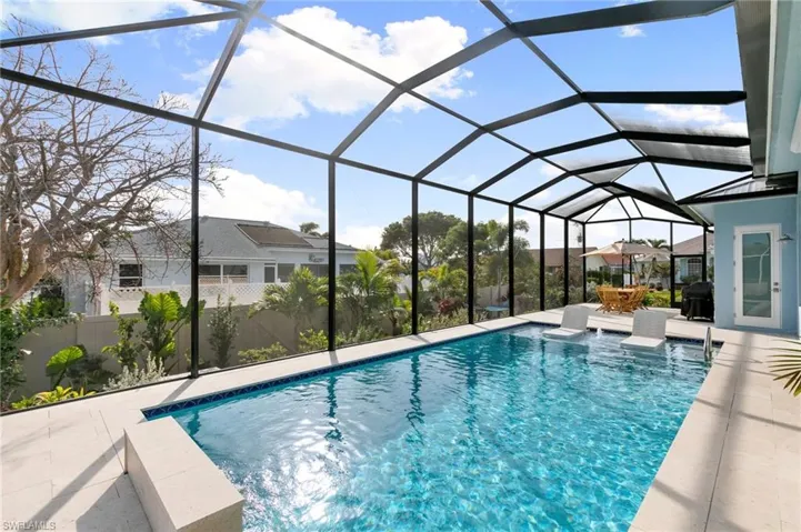 Pool with sun shelf and screened lanai