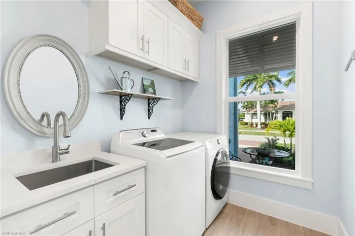 Laundry room with sink, storage, washer and dryer