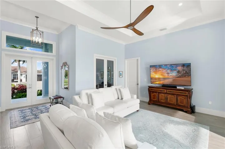 Living room with entry way and den in background