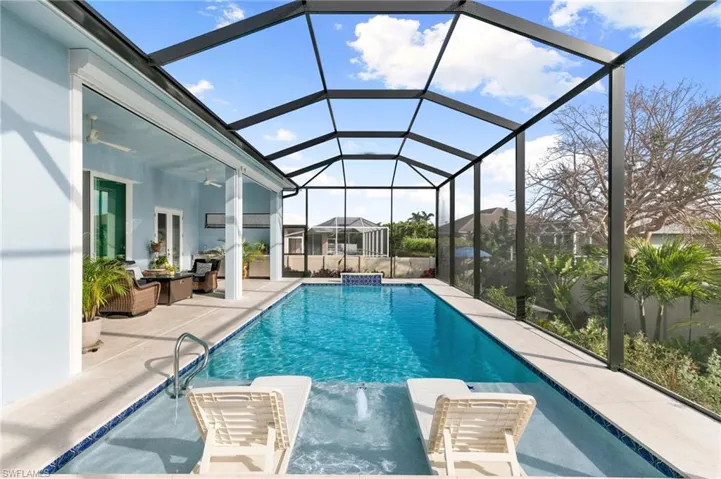 Pool with sun shelf, water feature, screened lanai