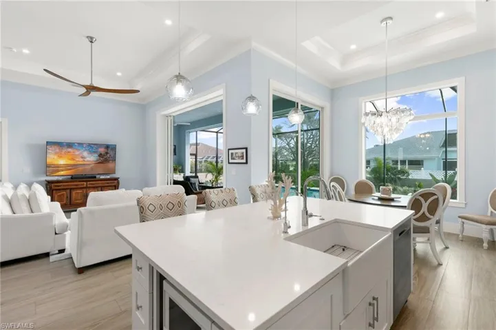 Kitchen with white cabinets, SS appliances, white quartz countertops, pendant lighting