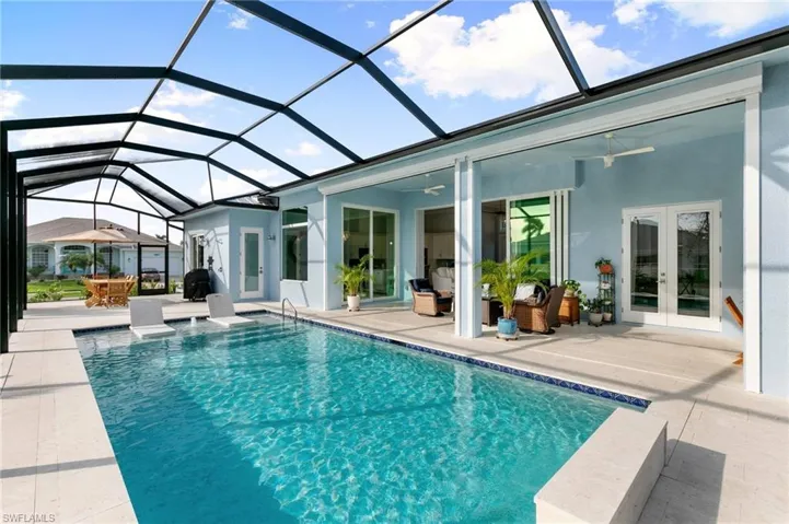 Pool featuring a patio, french doors, glass enclosure, and a ceiling fan