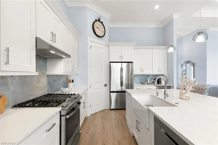 Kitchen with SS appliances, gas range, white quartz counters