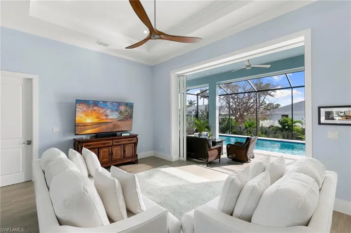 Living room with tray ceiling opening onto lanai
