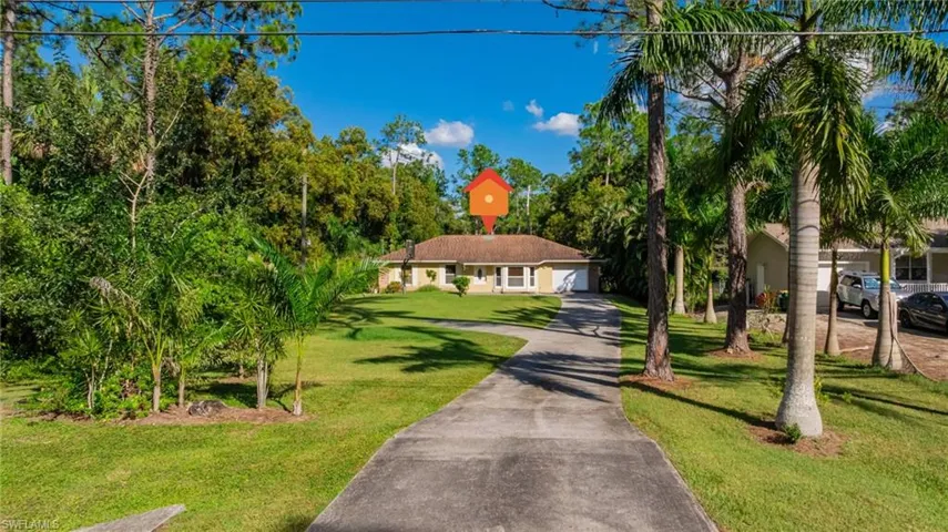 View of front facade with concrete driveway and a front lawn