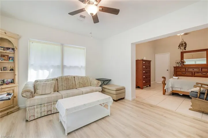 Living area with ceiling fan and light wood-style flooring