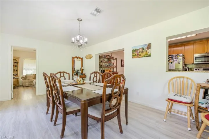Dining area featuring light wood finished floors and a chandelier