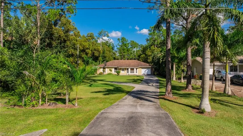 View of front of property with a front lawn and concrete driveway