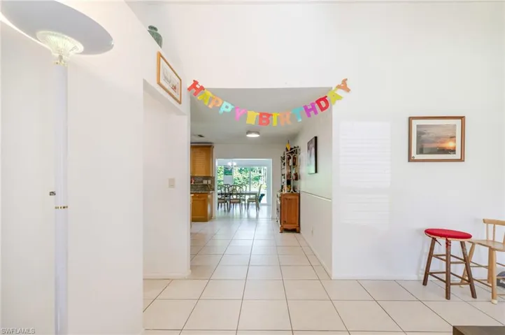 Hallway featuring light tile patterned flooring and baseboards