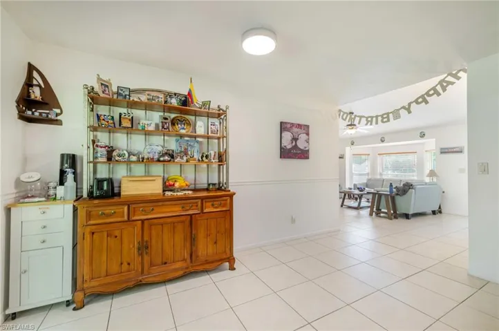 Bar featuring open shelves, light tile patterned floors, brown cabinetry, and ceiling fan