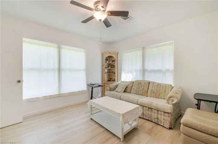 Living area with healthy amount of natural light, light wood-style flooring, and a ceiling fan