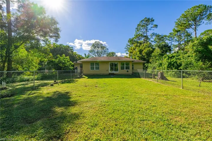 Rear view of property with stucco siding and a fenced backyard