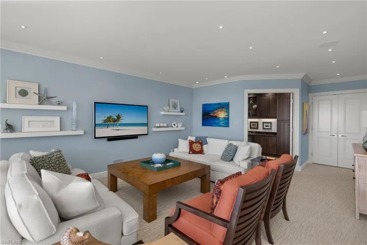 Living area featuring ornamental molding, recessed lighting, and light colored carpet