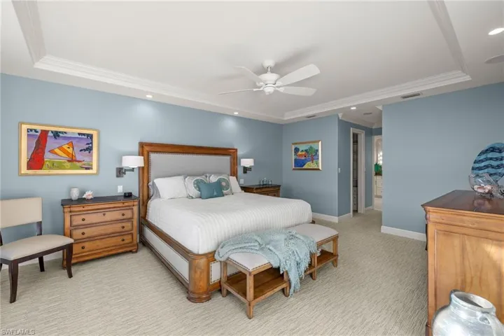 Bedroom featuring a raised ceiling, crown molding, a ceiling fan, recessed lighting, and light colored carpet