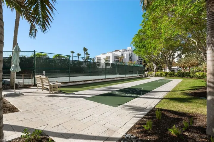 View of home's community featuring shuffleboard and a tennis court