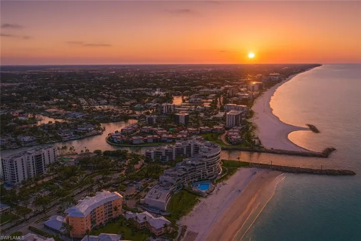 Aerial view at dusk of view of water and beach and a city view