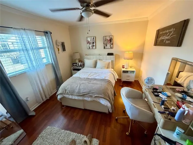 Bedroom with crown molding, wood finished floors, and ceiling fan