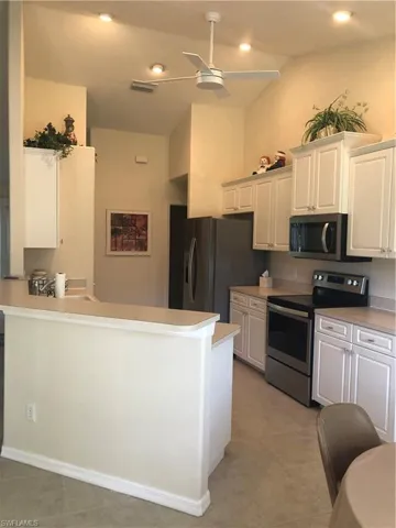 Kitchen with white range oven, light countertops, ceiling fan, a peninsula, and recessed lighting