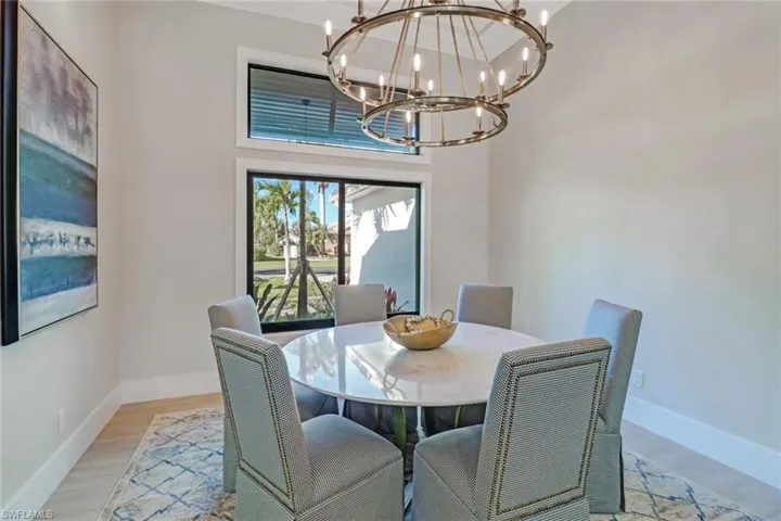 Dining area featuring light wood-style flooring and a towering ceiling