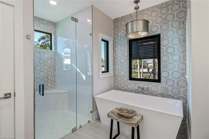 Bathroom featuring a freestanding bath, a shower stall, recessed lighting, and wood finished floors
