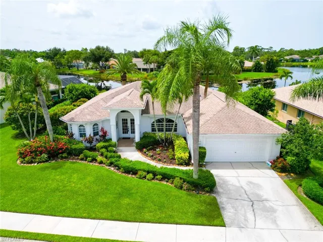 View of front facade featuring a garage, a water view, and a front lawn